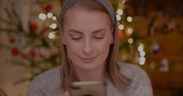 若い女性は自宅でスマートフォンでインターネットを閲覧 — ストック動画