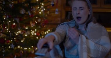 Evde televizyon izleyen bir kadın.