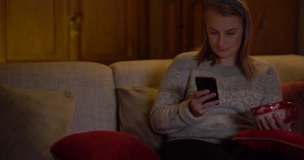 Junge Frau surft zu Hause auf Smartphone im Internet — Stockvideo