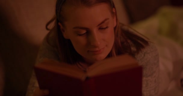 Mulher lendo livro deitado no sofá na sala de estar — Vídeo de Stock