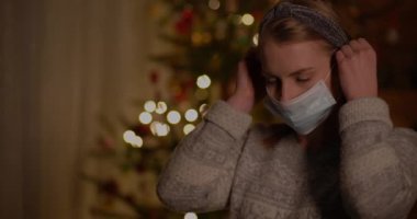 Noel 'de evde koruyucu maske takan kadın.