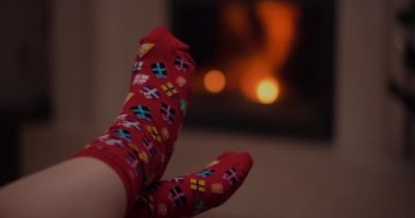 Sıcak yün çorap giyen kadın Noel 'de şöminenin yanında yatıyor. Xmas Arkaplanı.