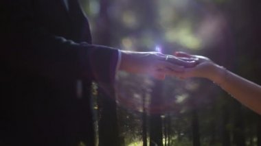 Güneşe karşı el ele tutuşan genç çift