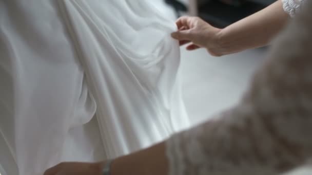 Свидетель корректирует свадебное платье невесты — стоковое видео