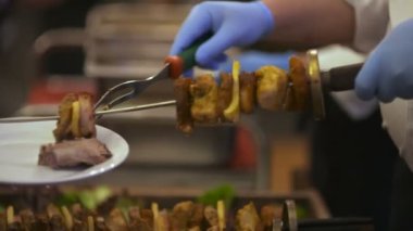 Şef şişlerini tabağa koyar.