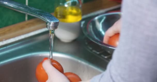 Le mani delle donne lavano verdure fresche. Pulizia pomodori. — Video Stock