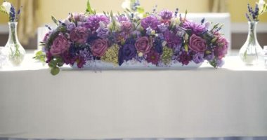 Çiçekli bir düğün yemeği için dekore edilmiş masa.