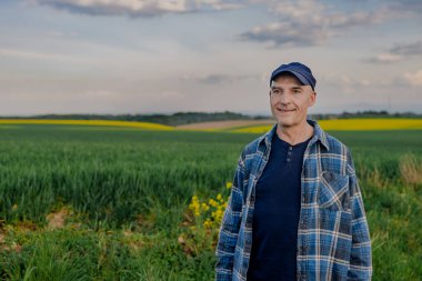 Tarlada çalışan başarılı çiftçinin portresi Buğday tarlasına bakıyor