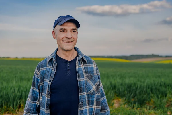 Tarlada çalışan başarılı çiftçinin portresi Buğday tarlasına bakıyor