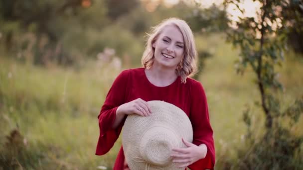 Portret van een positieve glimlachende vrouw die in de camera kijkt bij zonsondergang — Stockvideo