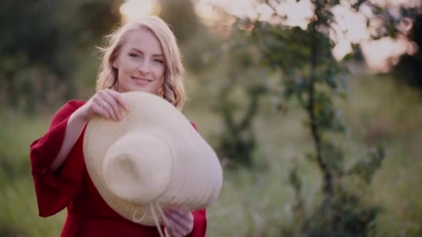 Portret van een positieve glimlachende vrouw die in de camera kijkt bij zonsondergang — Stockvideo