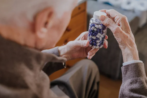 Son sınıf öğrencisi elinde haplarla şişeyi tutuyor.