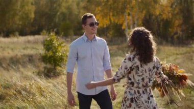 Çayır üzerinde yürüyen genç bir çift. Pozitif Genç Poeple Mutluluğu.