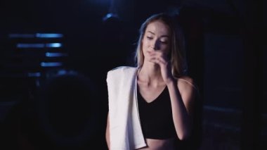 Omzunda havluyla spor salonunda kendine güvenen bir kadın.
