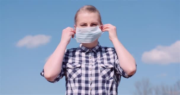 Mulher vestindo máscara protetora contra fundo Nuvens — Vídeo de Stock