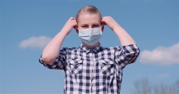 保護マスクを身に着けている女性はそれを削除し、深い新鮮な息を取る — ストック動画