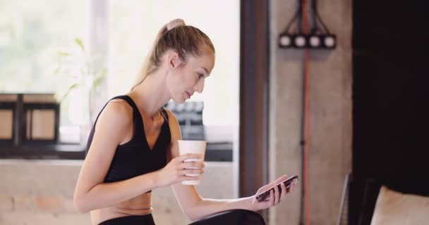 在健身房使用手机的女运动员 — 图库视频影像
