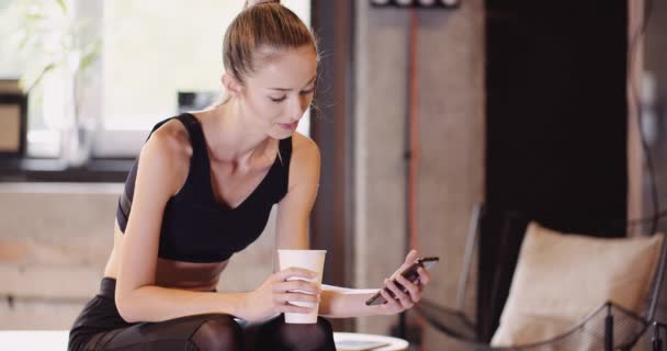 Sportos nő használ okostelefon a Health Club — Stock videók