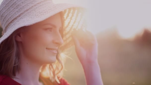 Retrato de una mujer sonriente positiva mirando a la cámara al atardecer — Vídeo de stock