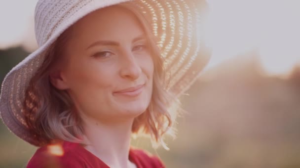 Retrato de una mujer sonriente positiva mirando a la cámara al atardecer — Vídeo de stock