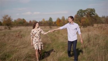 Genç çift ormanda el ele tutuşuyor..