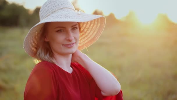 Retrato de una mujer sonriente positiva mirando a la cámara al atardecer — Vídeo de stock