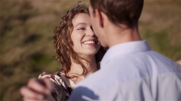 Man omhelzende vrouw, knuffelend en glimlachend naar elkaar. Gelukkig liefhebbend paar knuffelen. — Stockvideo