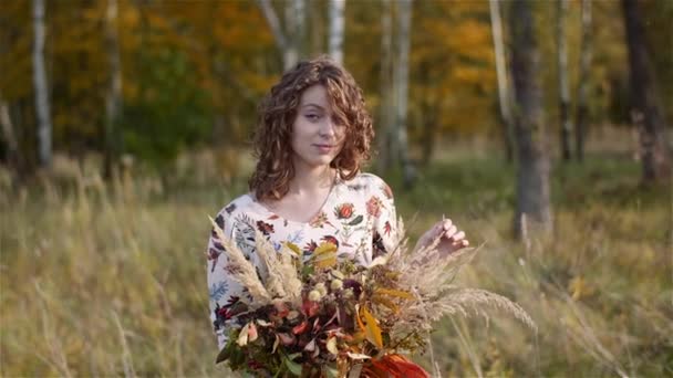 Портрет жінки, що дивиться на букет з диких квітів влітку . — стокове відео