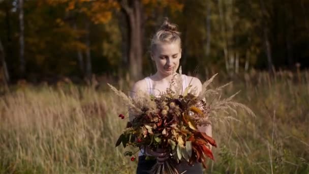 Vrouw op zoek naar boeket van wilde bloemen in de zomer. — Stockvideo