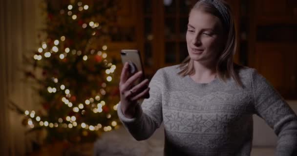 크리스마스 스마트폰으로 채팅하는 비디오 게임이나 비디오 채팅 비디오를 하는 여성 — 비디오