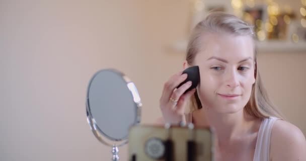 Junge Frau schminkt sich zu Hause vor Spiegel — Stockvideo