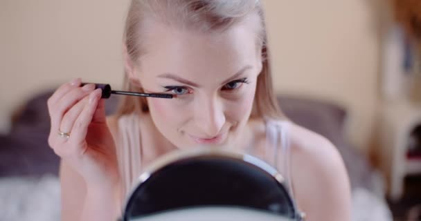 Жінка робить макіяж малює вії тушю — стокове відео