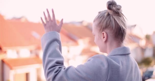 Заблокированный снимок женщины, машущей рукой, стоя на крыше — стоковое видео