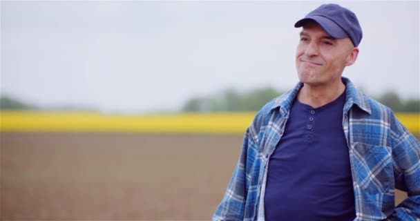 Agricultor exitoso positivo que examina el campo agrícola mientras trabaja en la computadora digital de la tableta. — Vídeos de Stock