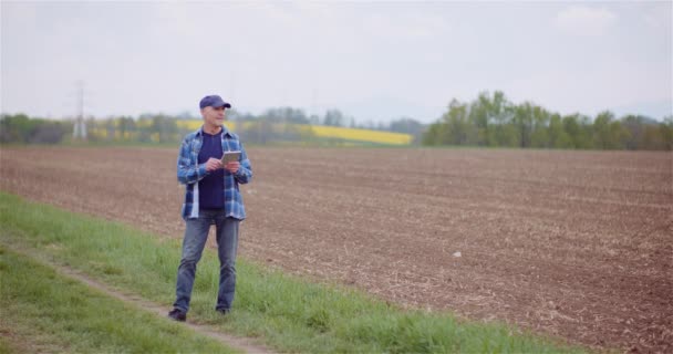 Landwirt untersucht landwirtschaftliches Feld bei der Arbeit am digitalen Tablet-Computer auf dem Hof. — Stockvideo
