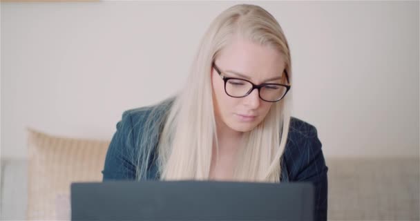 Mulher sorrindo e balançando a cabeça enquanto usa um computador portátil — Vídeo de Stock