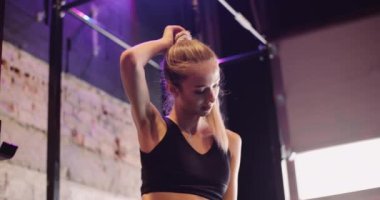 Spor salonundaki kendinden emin genç kadının portresi.