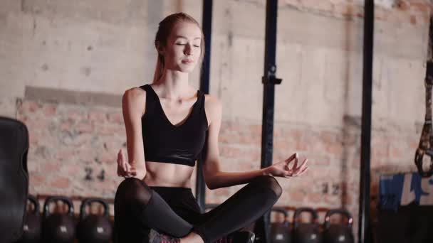 Fit Young Woman Meditating In Gym. Cvičení jógy ve fitness studiu. — Stock video