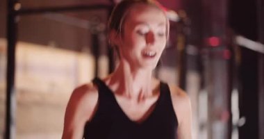 Kendine güvenen bayan sporcu kardiyo çalışması yapıyor.