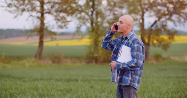 Rolnik rozmawiający przez telefon komórkowy podczas pracy w rolnictwie — Wideo stockowe