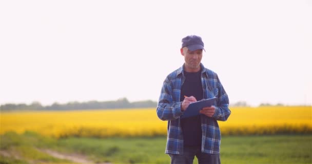 Jordbrukare talar i mobiltelefon när de arbetar inom ett lantbruk — Stockvideo