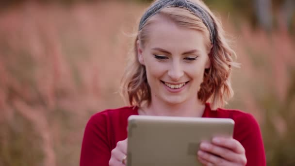 Glimlachende vrouw met behulp van digitale tablet buiten in de zomer — Stockvideo