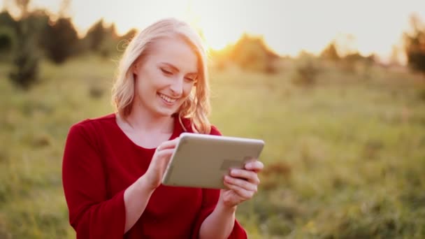 Glimlachende vrouw met behulp van digitale tablet buiten in de zomer — Stockvideo