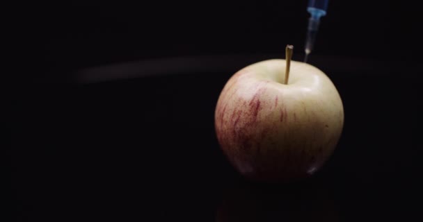 Genetyczna modyfikacja żywności - strzykawka do wstrzykiwania płynów w jabłku. Koncepcja modyfikacji GMO. — Wideo stockowe