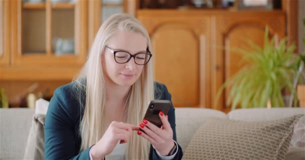 Бізнес-леді використовуючи мобільний телефон на дивані — стокове відео