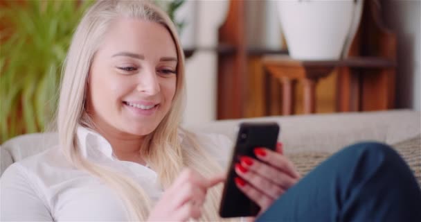นักธุรกิจหญิงใช้โทรศัพท์มือถือบนโซฟา — วีดีโอสต็อก