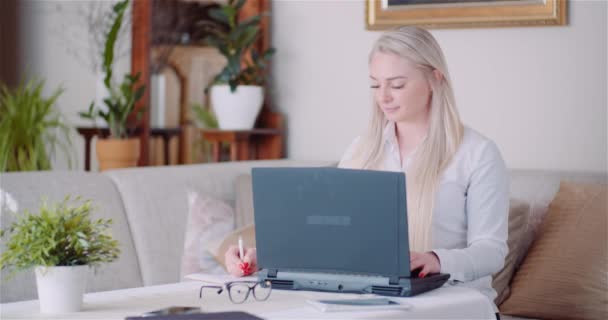 Mulher de negócios trabalhando no laptop em um projeto no Home Office. Jovem mulher usando computador portátil. — Vídeo de Stock