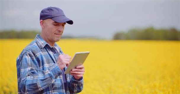 農場でデジタルタブレットPCを操作しながら農業分野を調べる農家. — ストック動画