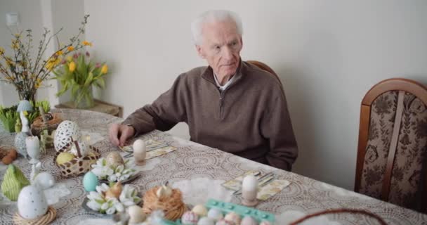 Altenpflege - Frau bereitet Tisch für Ostern. — Stockvideo