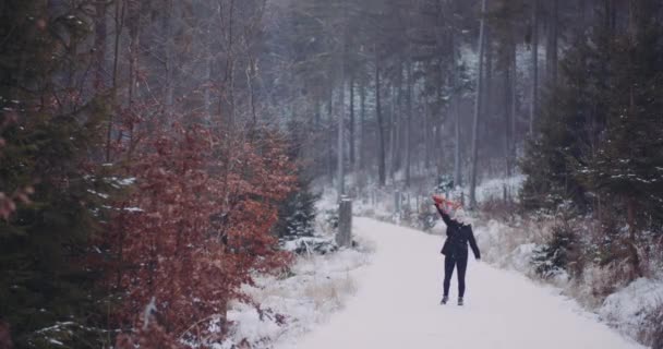 žena pohybující šátek v zimě v lese